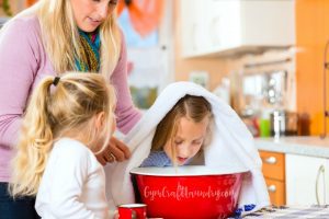 A mother trying a home cough remedy for her child